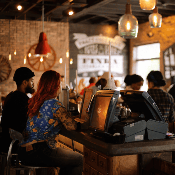 People sitting at a table in a cafe next to Cafe Epos System running PixelPoint Pos
