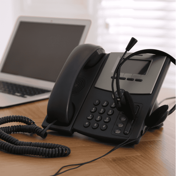 a cloud voice powered telephone on a desk next to a laptop
